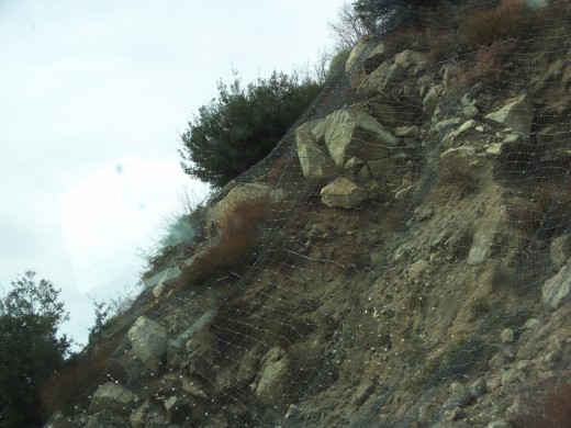 Netting used to keep rocks from sliding down the hillside on to Highway 18.