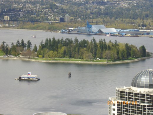 Part pf Stanley Park is in the foreground and North Vancouver lies in the background in this overview of Burrard Inlet.