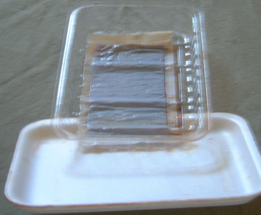 Plastic Lid, Styrofoam and then wrapped in plastic wrap. This held beef liver. 