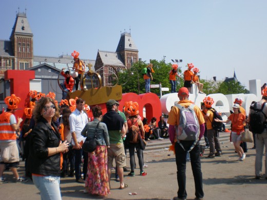 The iconic "I amsterdam" at Museumplein, surrounded by celebrating crowds.