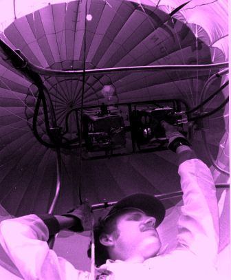 An unusual angle of a hot air balloonist checking his equipment.