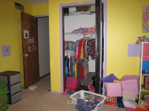 The floor of her closet is completely covered with...well junk.