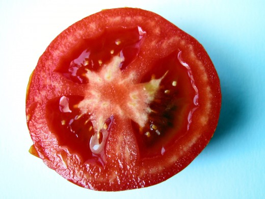 Squeeze tomatoes to remove the pulp and seeds.