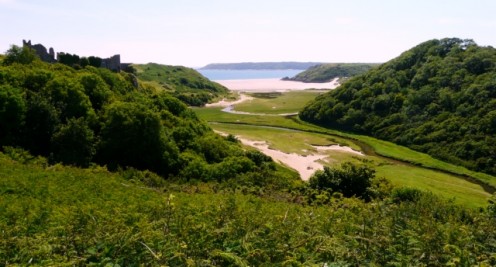 Pennard Pill, looking down the Pennard Valley to the sea, the ruined Pennard Castle is visible at the top of the cliff on the left