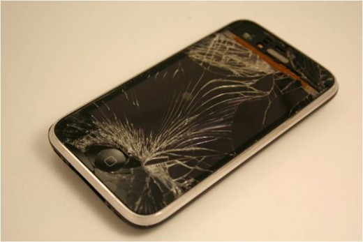 Completely shattered front face: Much of the glass has chipped away around the upper area of the screen exposing the orange digitizer.