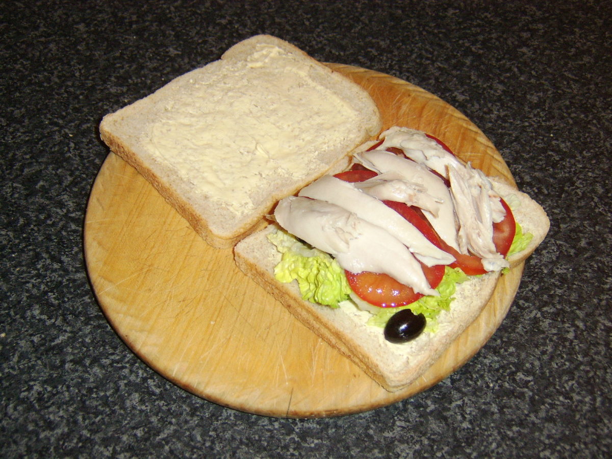 Chicken and tomato are laid on top of the lettuce