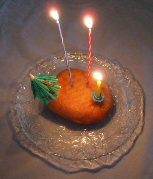 A single donut with birthday candles and paper umbrella decoration make aging brag-worthy.