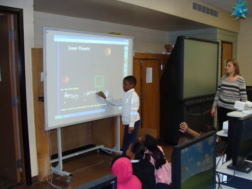 Students interacting with the Promethean Board.