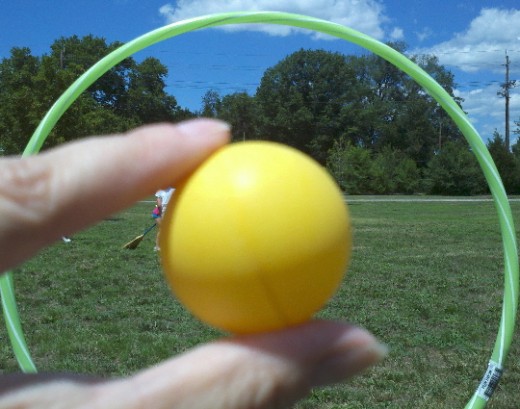 The golden snitch takes a peek from behind a hoop goal post.