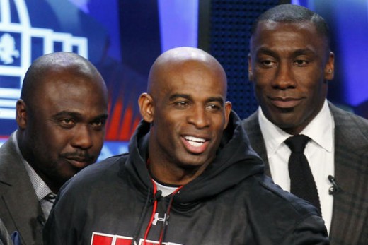 Former NFL players Deion Sanders, Marshall Faulk (L) and Shannon Sharpe (R) stand together after they were named to the Pro Football Hall of Fame during a ceremony in Dallas, Texas February 5, 2011. Lucy Nicholson/Reuters