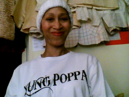 Victoria Moore in a "Yung Poppa" t-shirt and white knit cap made by Sylvia A. from Koloa, Hawaii for "The Giving Caps Group".