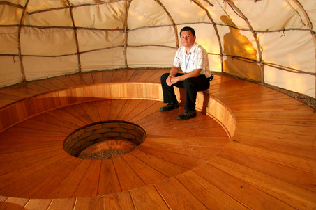An Oglala Sioux man sits inside a sweat lodge.