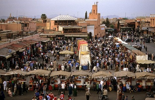 Marrakech - Marocco View from Caf Glacier: Place Djamaa el-Fna Background is the Mosquee Quessabine. In front are stands of orange juice seller.