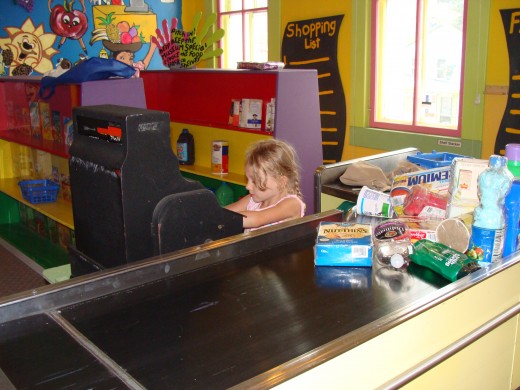 Grace is pretending to be a cashier at the store.