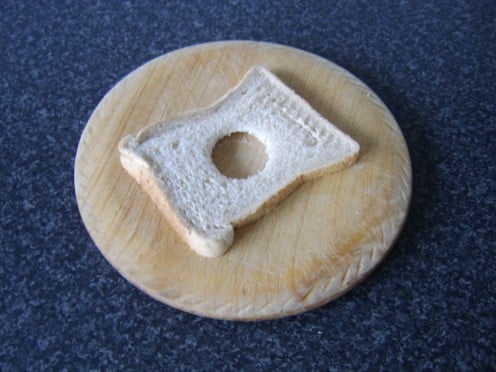 A hole is cut in the centre of the bread with an egg cup