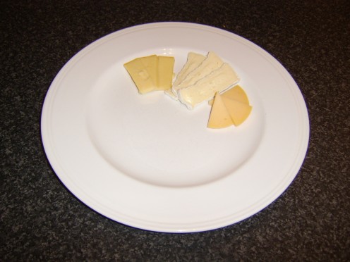 Cheeses are sliced and added to a serving plate