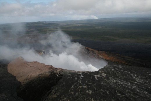 Pu'u O'o, Nov 2009. On the horizon, the main summit crater of Kilauea Volcano is also erupting. Kilauea is a huge, flat "shield volcano" which is thousands of feet high, but its lavas spread out almost horizontally, building like a giant mud patty.