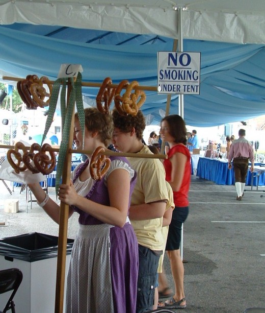 Pretty German girl sells hot pretzels with flair.