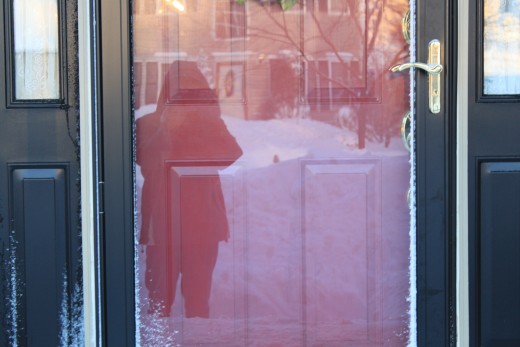 a photo of me in the reflection of the front door, notice how high the snow comes up in the front yard, up to my hip! and im 5'10, probably 5'11 with snow boots on!