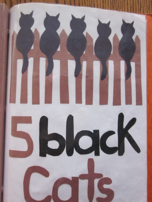 5 Black Cats Sitting on a Fence!