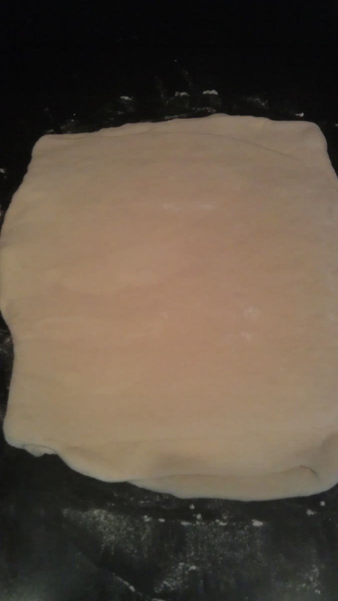 You'll see faint blobs of yellow butter underneath the dough surface. There are many alternating layers of dough and butter now.