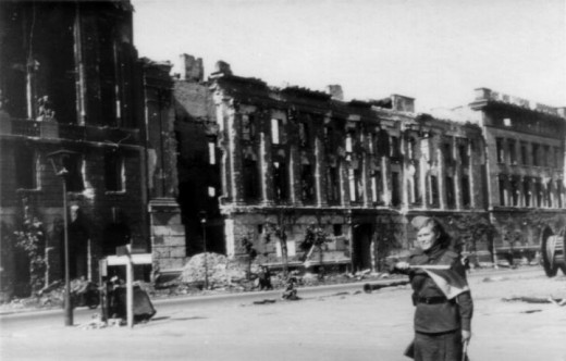 Berlin, Unter den Linden, crossing with Wilhelmstraße, begin of May 1945, Soviet soldier as traffic policewoman in front of the ruins of the houses Unter den Linden # 76, 74 and 70-72 (from left)