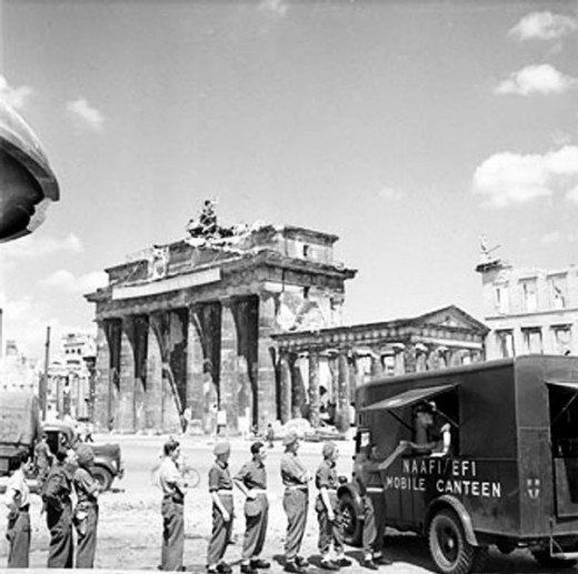 British soldiers queue for tea at NAAFI Mobile Canteen No. 750 beside the Brandenburg Gate, Berlin. This van was the first mobile NAAFI to operate in Berlin.