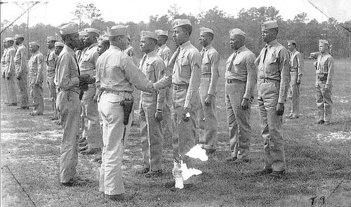 Lt. Col. Frazier, Commanding Officer, Montford Point Camp, presents WWII Victory Medal to members of the Montford Point Camp, and the 51st, and 52nd Defense Battalions.  From the collection of Joseph H. Carpenter.