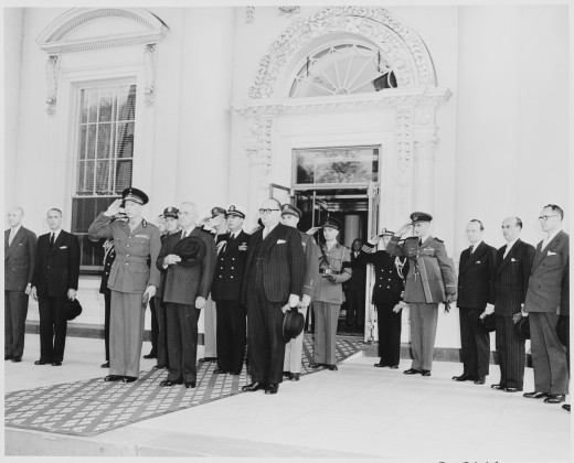 Prince Charles of Belgium and President Truman and other dignitaries stand at attention in the entranceway to the White House, 1948