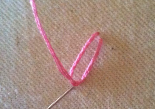 Figure 4: Push the needle back in on the outside of the loop to "tie down" your petal
