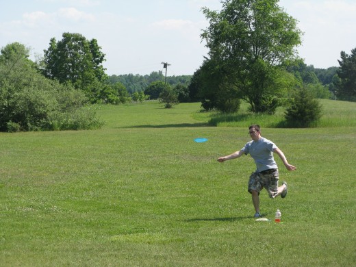 Disc golf drive photo - Sometimes you can get a good approach shot that is not on the tee box.  This one had nearly perfect timing with the disc just coming off the subjects fingers.
