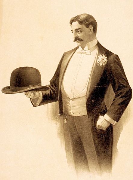 Lithograph poster showing a man wearing a tailcoat and holding a bowler hat (file name incorrectly refers to the coat as a tuxedo)