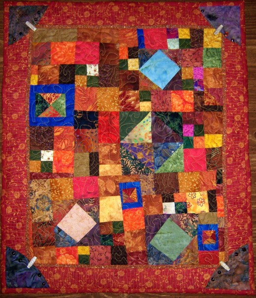This scrap quilt uses mainly warm color fabrics, with a few cool fabrics for contrast.