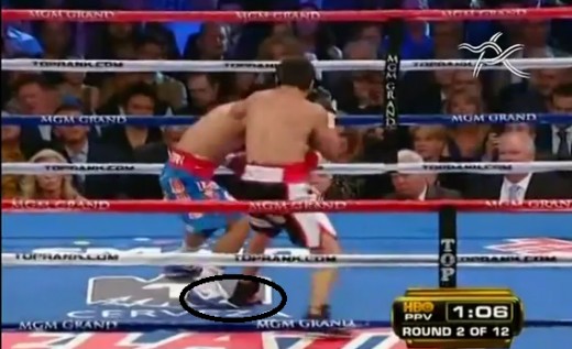 The image shows that Marquez in black trunks is seen stepping on Pacquiao's foot, an ingenious way of neutralizing the speed  of an opponent