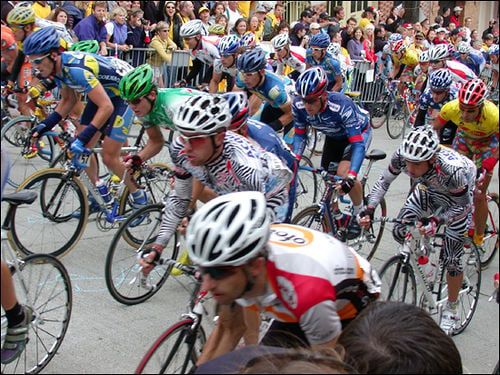 Lance Armstrong (centre in blue behind guy in zebra print) climbing a hill out of the saddle- you can tell they're all working hard against gravity