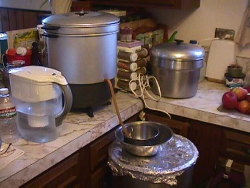 Temperature-controlled electric pot on the bottom.  Steam distiller on the top. Under the bowl are leftover grape solids (from juicing the grapes) making into balsamic vinegar.
