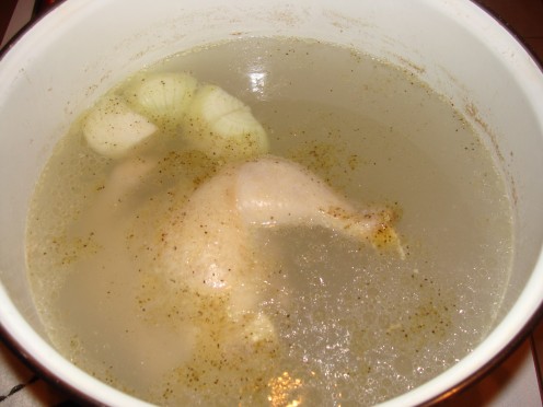 Boiling the chicken and vegetables to make the broth.