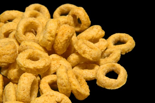 Pile of honey loops breakfast cereals isolated on black.