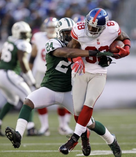 New York Jets' Darrelle Revis, left, tries to  Dec. 24, 2011, in East Rutherford, N.J. (AP Photo/Julio Cortez)