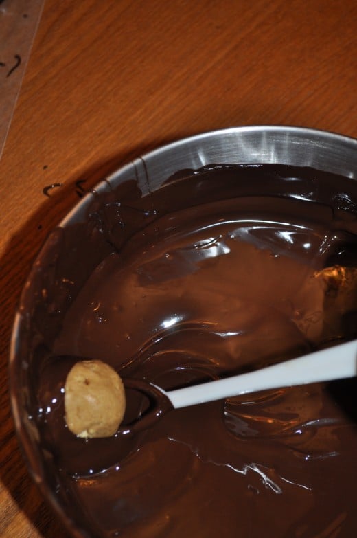 I have a special tool just for dunking candies but a fork would work just as well. Make sure the entire ball is covered in chocolate. Work quick. The chocolate is hot and can cause the peanut butter balls to get soft.