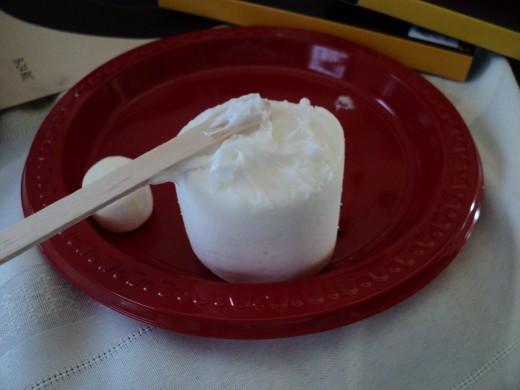 Place a dollop or quarter sized scoop of frosting on the bottom of the jumbo sized marshmallow.