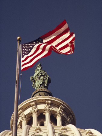 An American Flag and the Statue of Freedom Atop the Capitol Dome