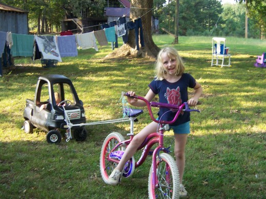 8 year old Betty Jean playing in the back yard at our old house.  She had been pulling her little sister in the car.
