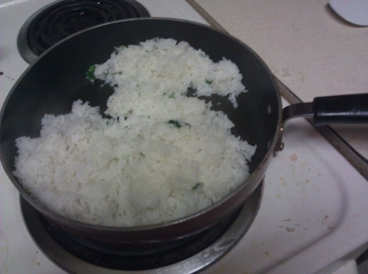 Here I combine about 4 cups of leftover rice with the green onions in a skillet.