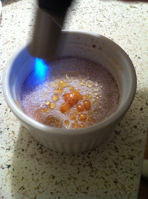 Burning the sugar on top of the creme brulee
