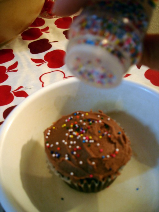 Set the cupcake in a small bowl or dish to keep the sprinkles from rolling all over the place!