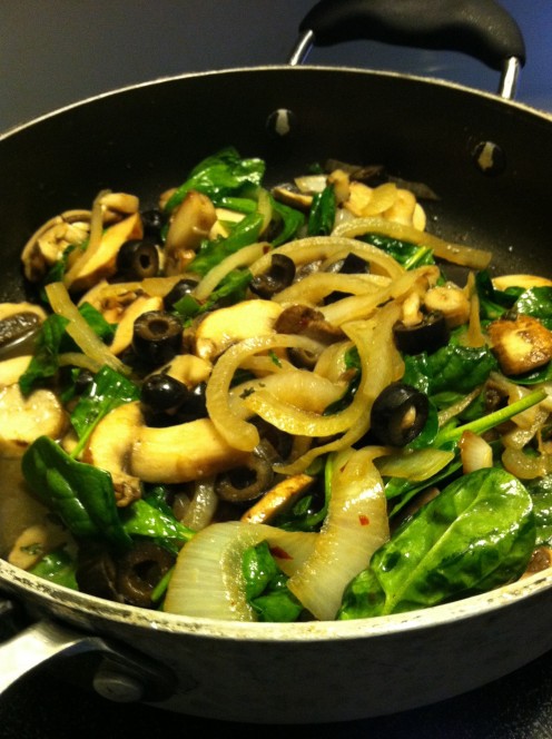 Sauteéing onion, mushroom, sliced black olives, and fresh green spinach in olive oil & minced garlic for topping pizza.