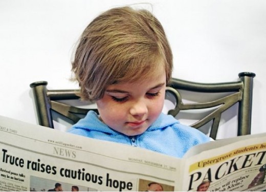 child reading a newspaper
