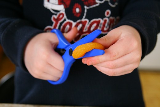 Use children's safety scissors to cut the dried fruit.
