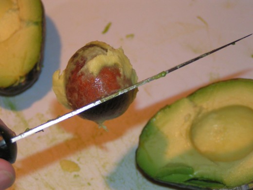 Turn and twist knife to remove seed/pit from avocado flesh.